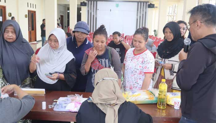 Warga berbondong-bondong membeli paket sembako murah dalam Operasi Pasar di Balai Desa Sumberejo, Kota Batu, Jawa Timur